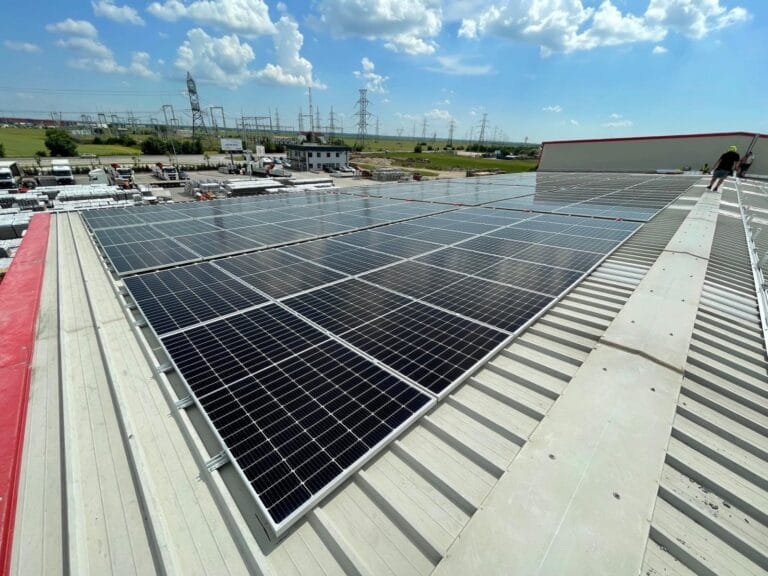 Panouri solare montate pe acoperisul din tabla al unei hale industriale